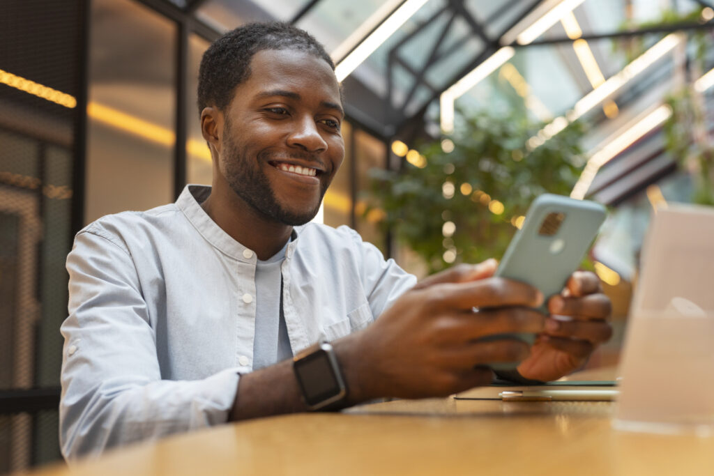 photo-of-a-man-sitting-behind-a-desk-and-laptop-on-his-phone-saving-money-with-revolut