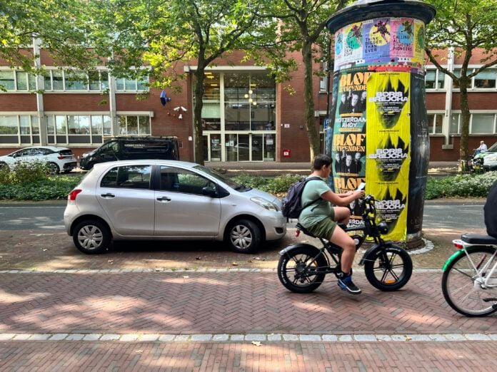 young-man-using-phone-while-riding-fat-bike-in-the-netherlands