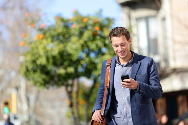 young-professional-in-the-netherlands-smiling-at-phone-after-starting-job-with-30-percent