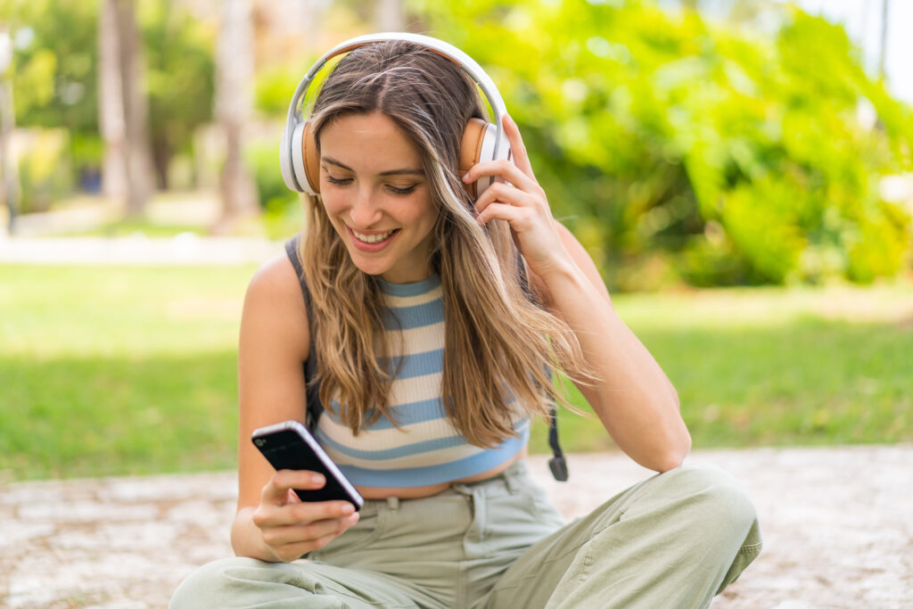 young-woman-listening-to-music-with-her-mobile-and-headphones-via-simyo-esim-with-mobile-data