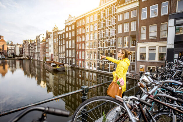 Young Woman Yellow Raincoat Enjoying Morning View Beautiful Cityscape View Amsterdam Scaled E1671625147771 629x420 