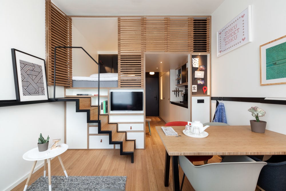 photo-of-hotel-room-at-zoku-amsterdam-with-table, stairs, artwork, and bed